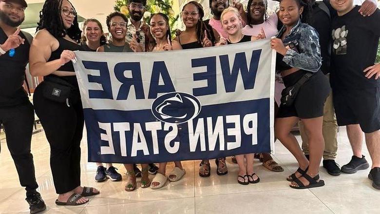 A group of people posing with a We Are Penn State sign